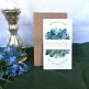 Boho Hochzeitseinladung aus Kraftpapier mit Greenery Blättern und Federn in Blau, Grün und Türkis
