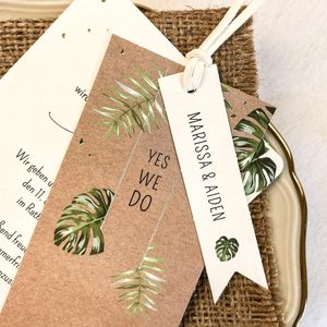 Hochzeitseinladung mit grünen Blättern auf Kraftpapier und kleinem Namensschild