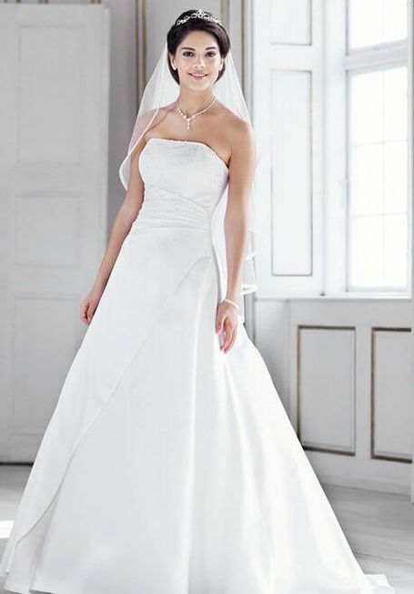 Schulterfreies Brautkleid in Weiß. Kunstvoll glitzernde Rankenbestickungen aus Perlen und Pailletten verleihen dem Kleid eine traumhaft edle Optik und blitzen auch entlang.