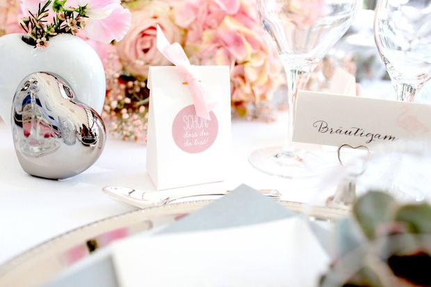 Weiße Kartonage mit Herzausschnitt für Hochzeitsmandeln in rosa Tischdeko