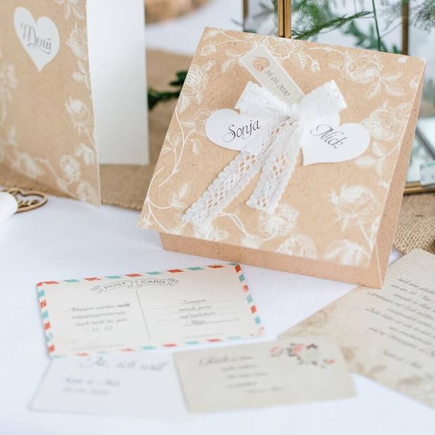 Einladungskarte zur Hochzeit auf Kraftpapier mit Herzen und Spitze